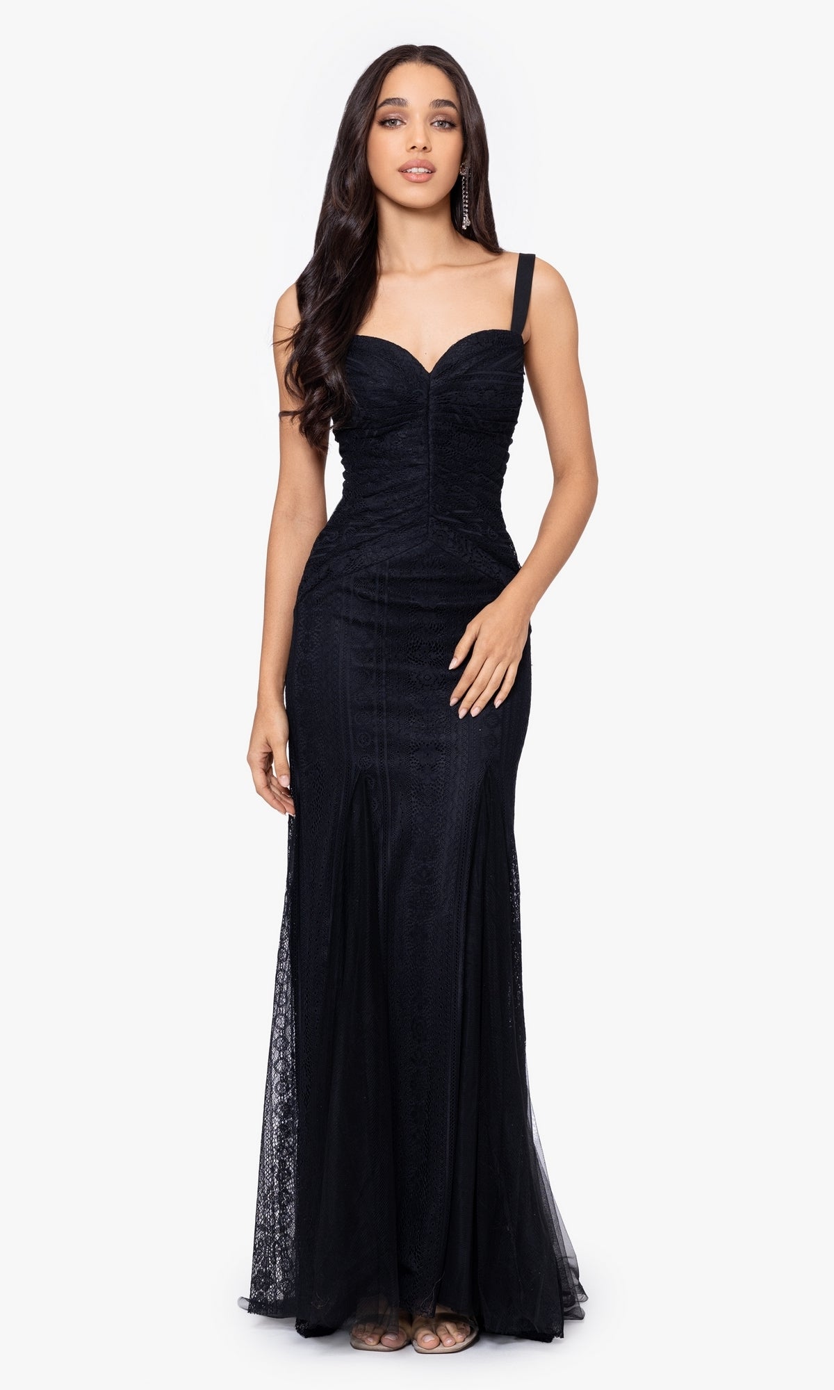 A woman stands facing forward, wearing the Long Prom Dress 4591BN by Blondie Nites—a black lace fitted gown with thin straps, a sweetheart neckline, and a chic lace-up back for an elegant formal look.